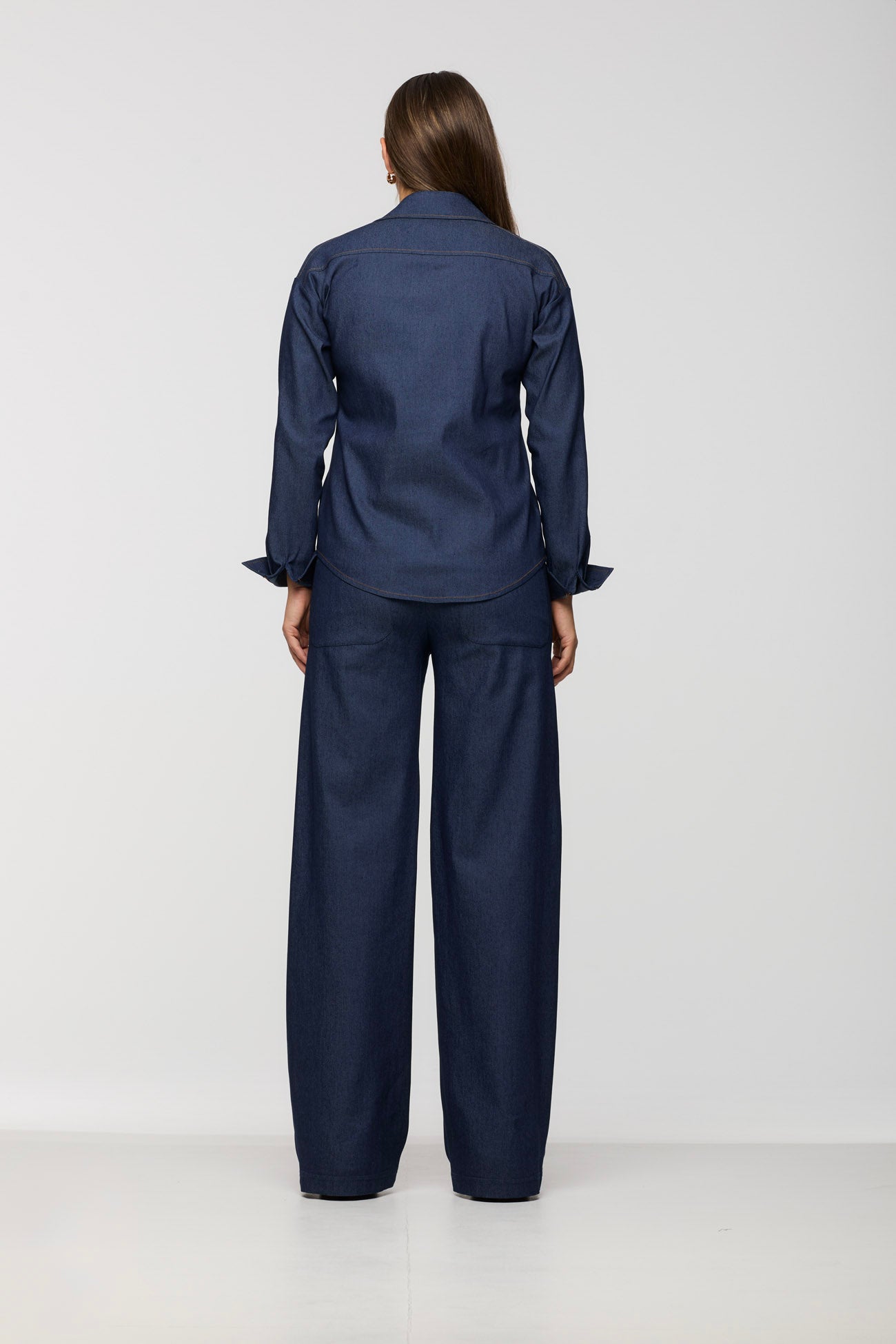 Person wearing a navy blue outfit on a white background