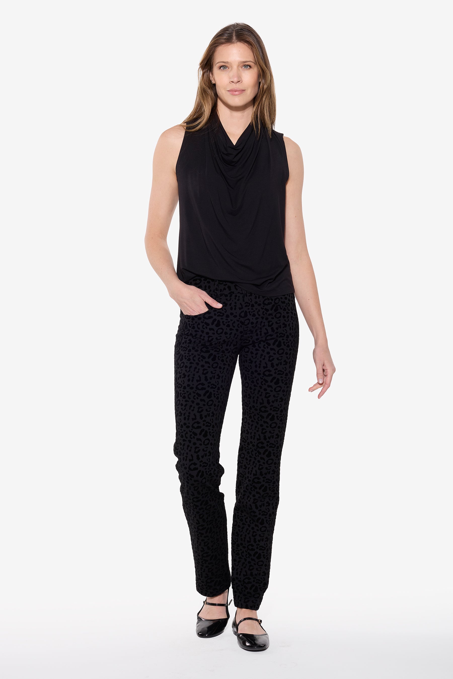 Woman wearing a black sleeveless top and black pants on a white background