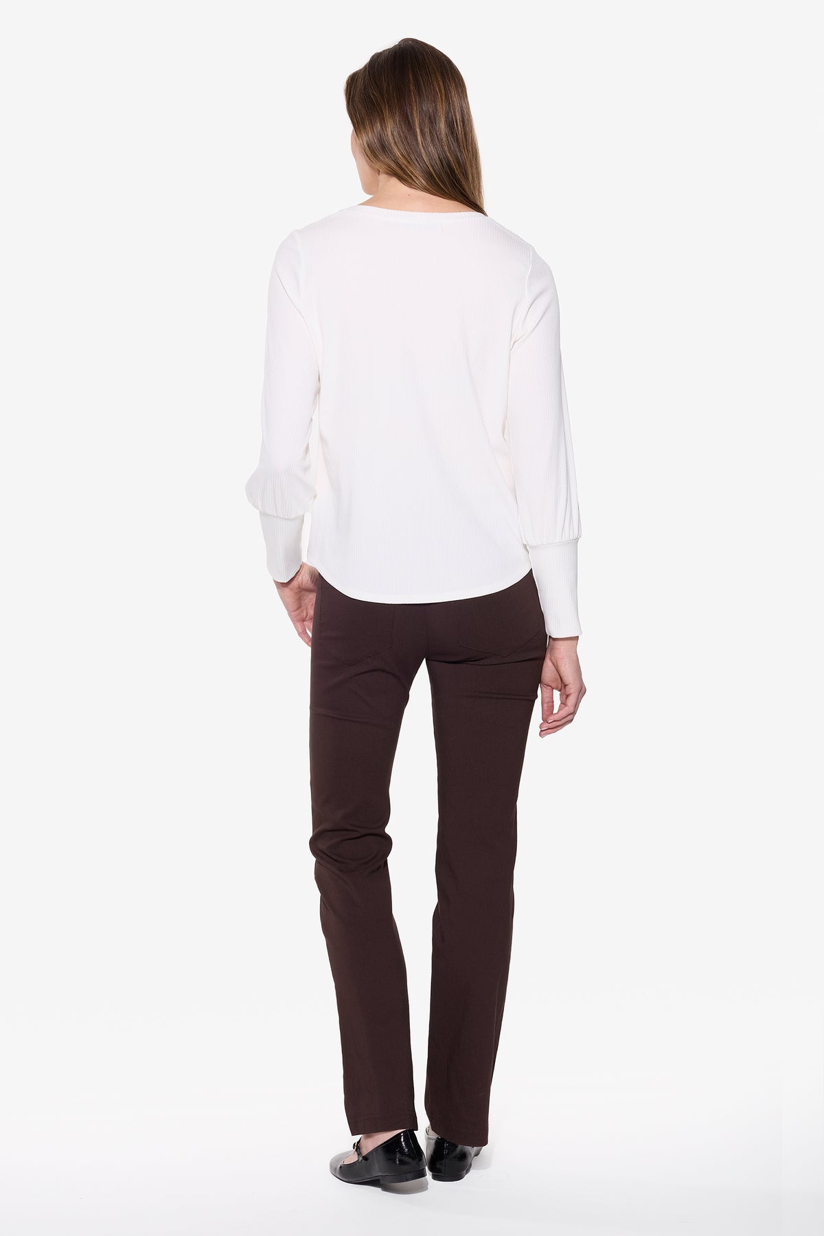 Person wearing a white shirt and brown pants on a white background
