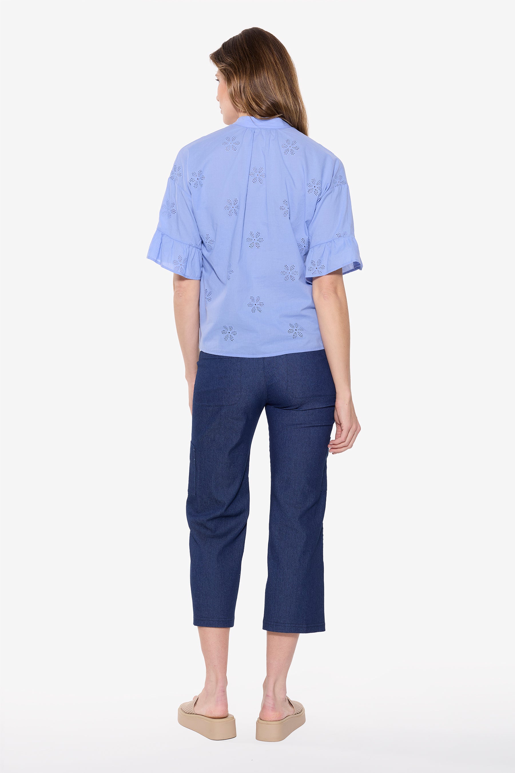 Back View of women wearing blue eyelet top and cropped indigo wide leg cargo pant