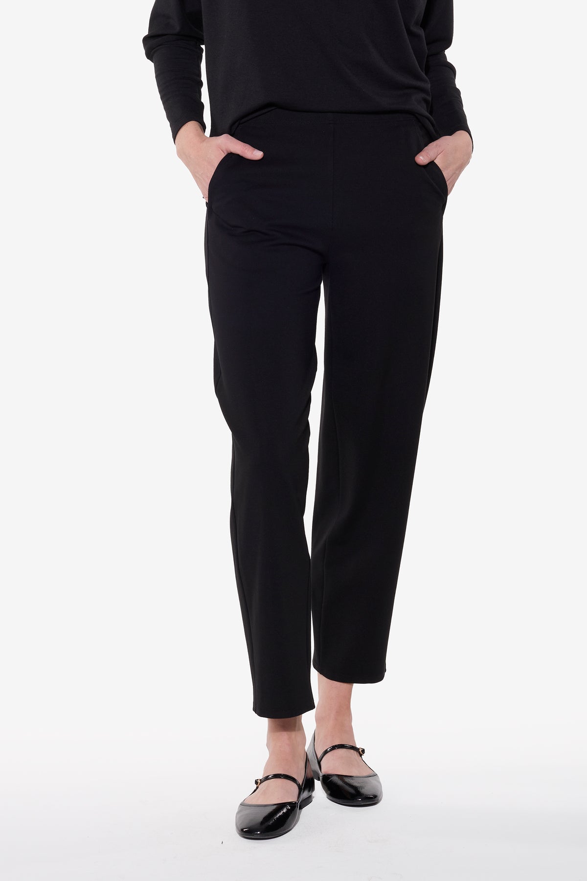 Person wearing black pants on a white background