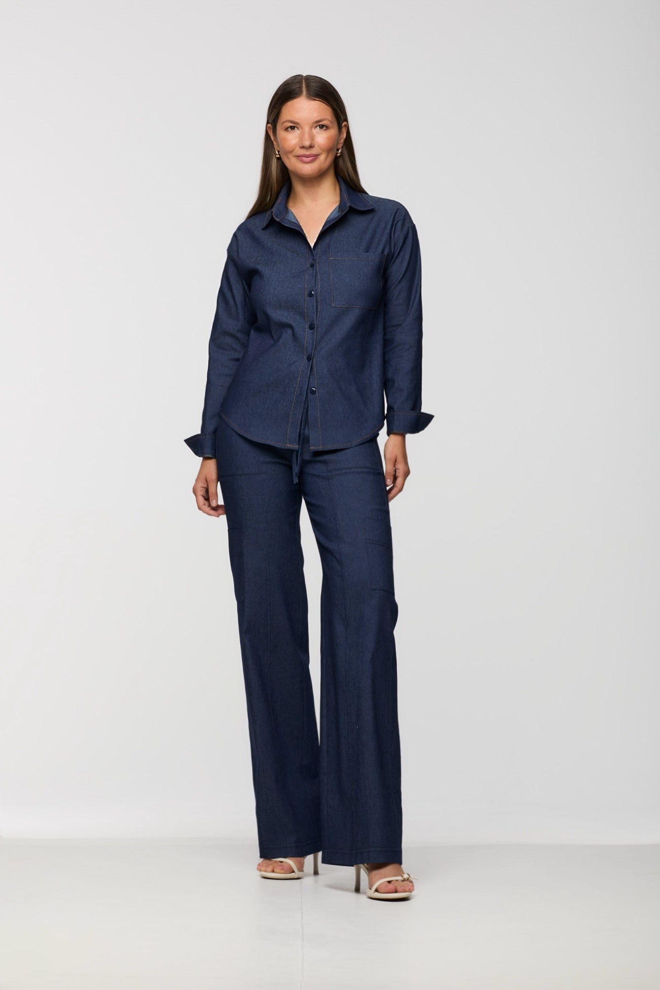 Woman wearing a navy blue shirt and pants on a white background