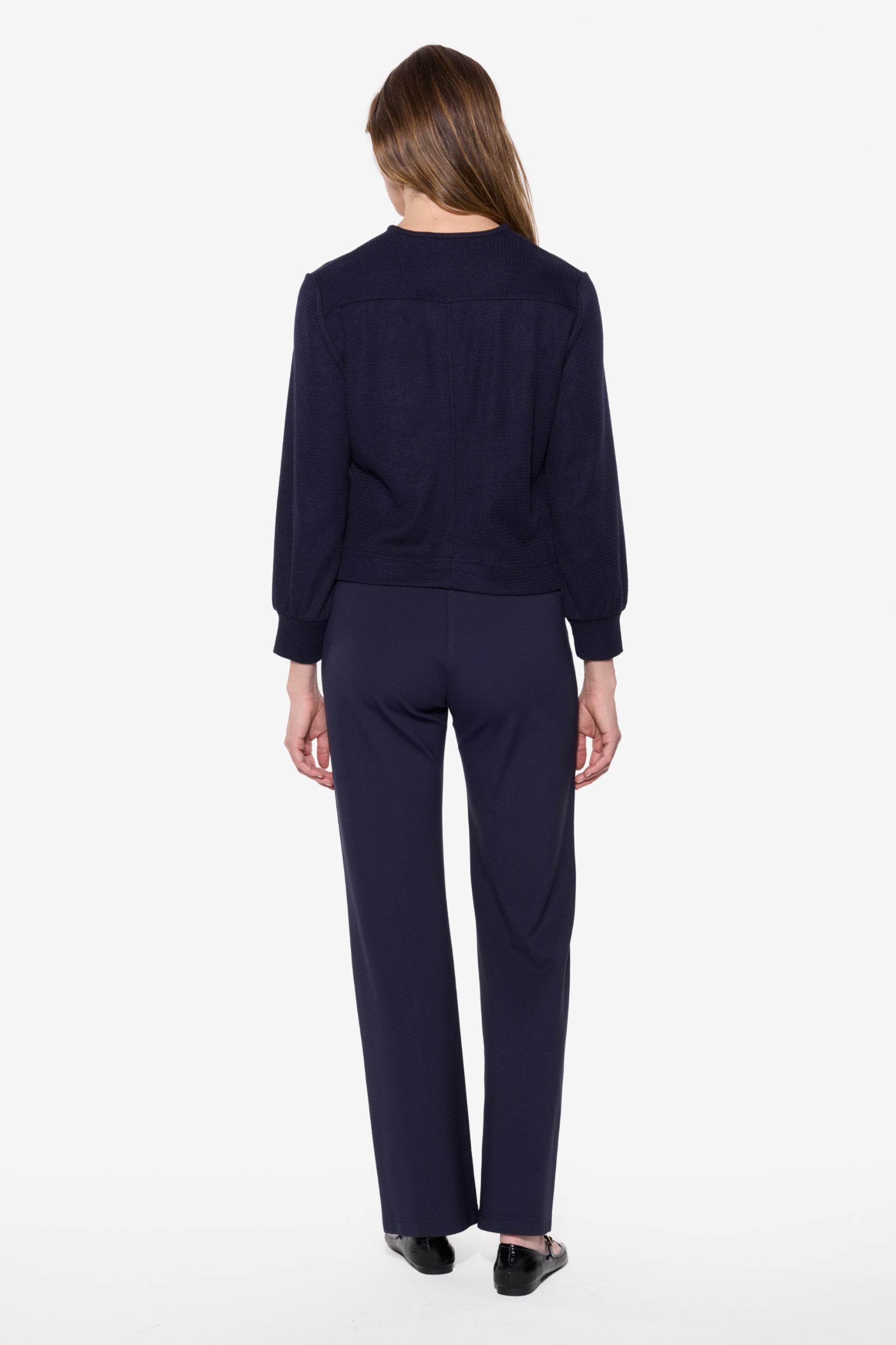 Person wearing a navy blue outfit on a white background