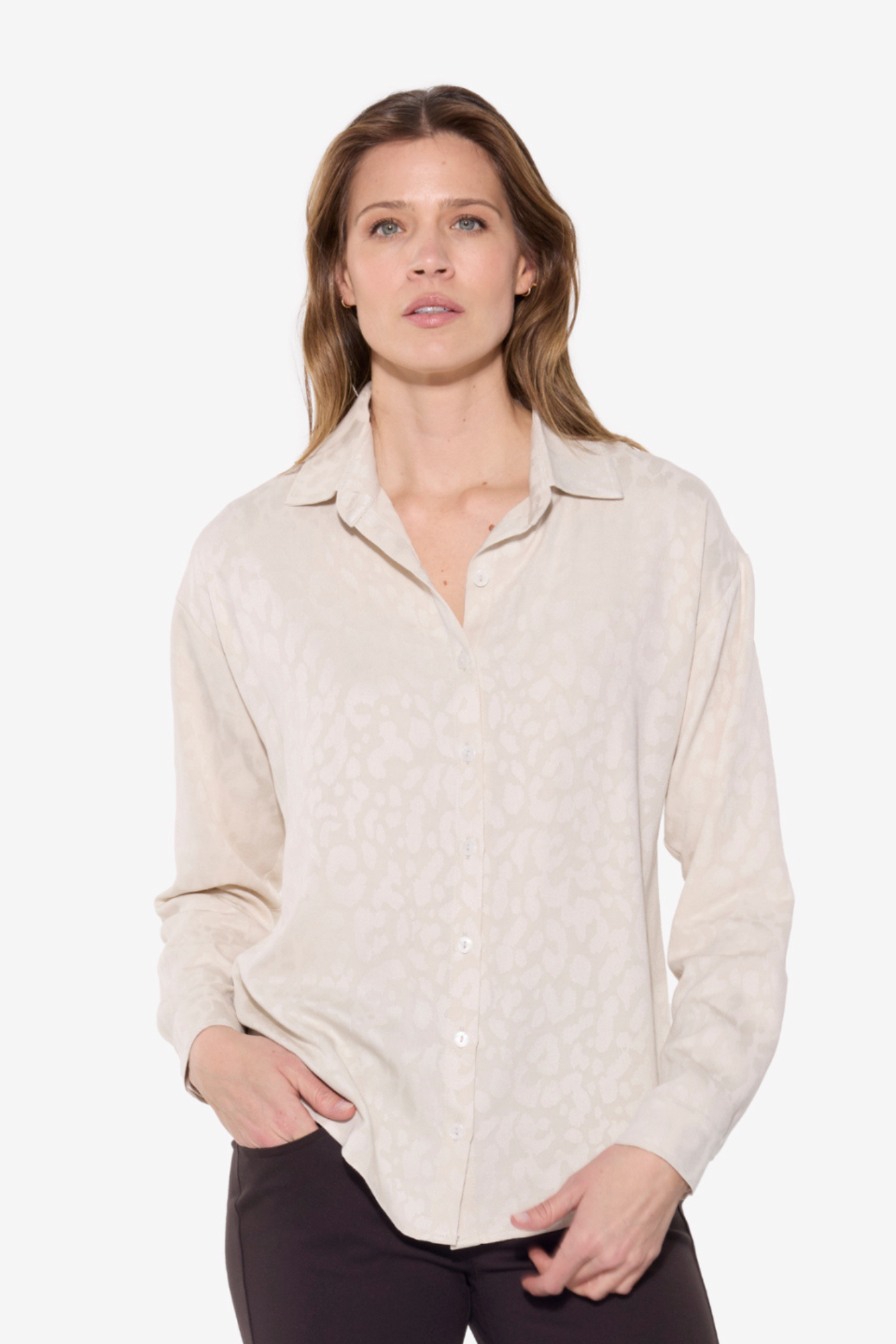 Woman wearing a cream-colored button-up shirt on a white background