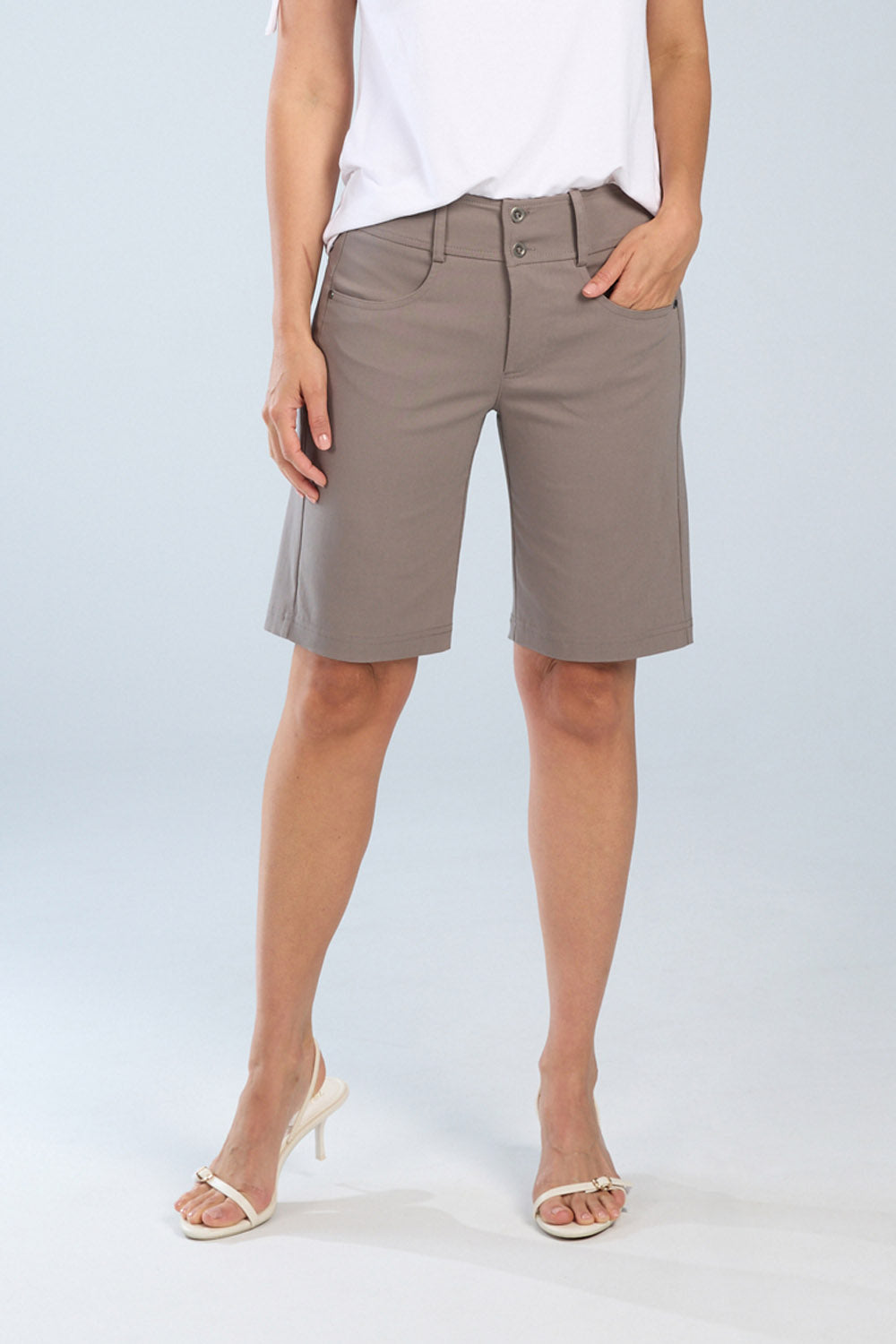 Person wearing beige shorts on a plain background