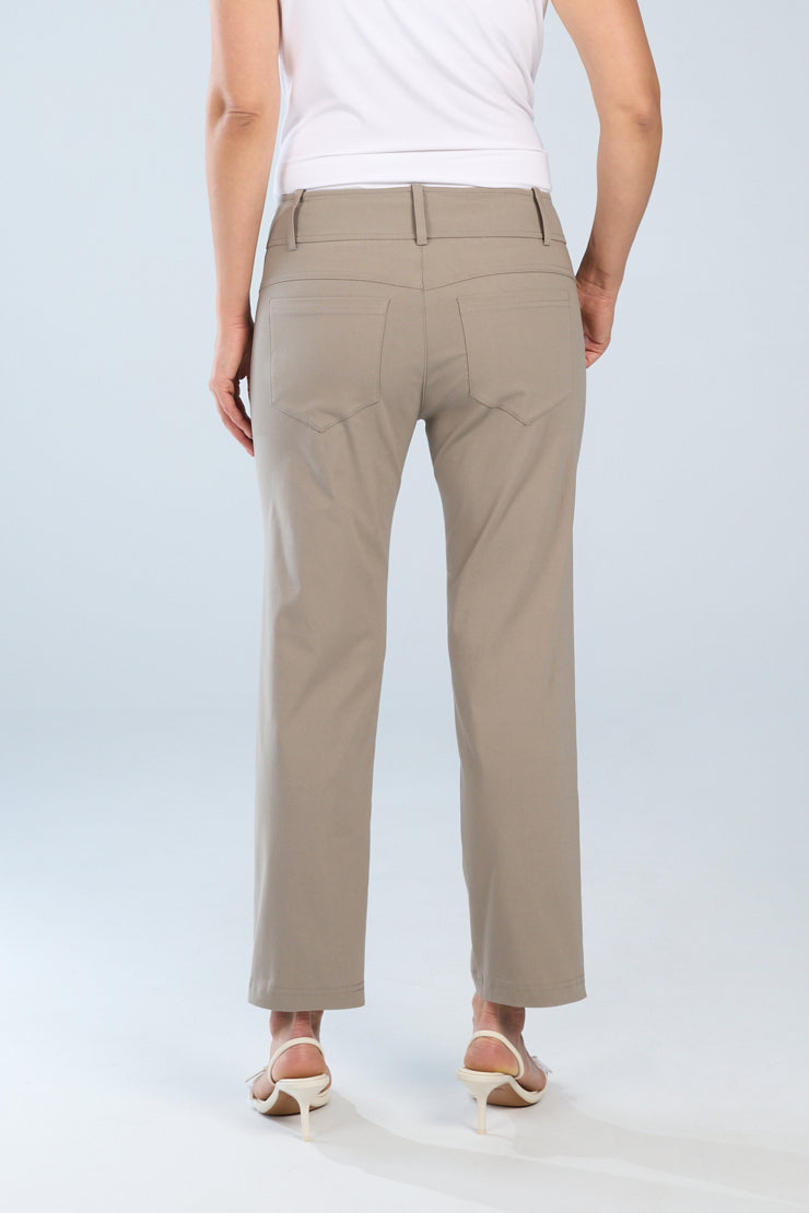 Person wearing beige pants and a white top on a light gray background