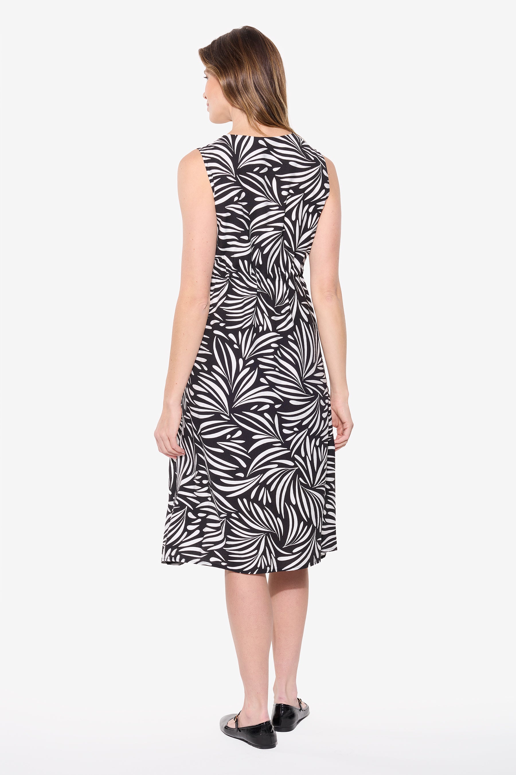 Woman wearing a black and white printed sleeveless dress from the back with adjustable waist and relaxed fit