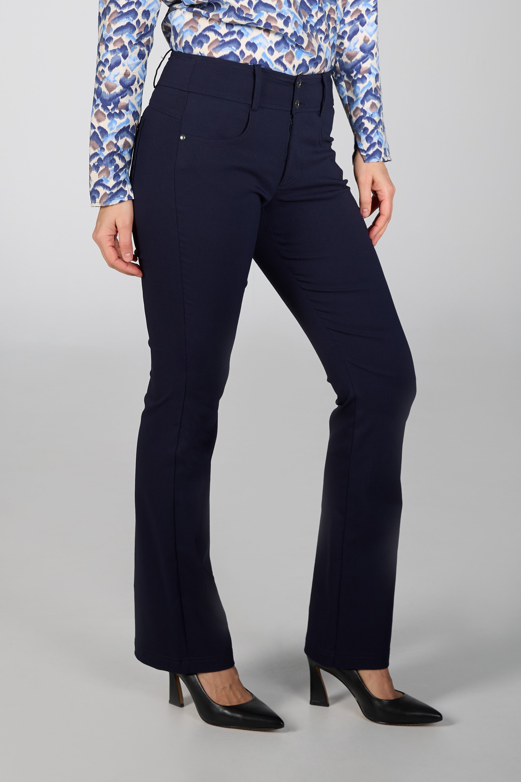 Navy blue pants worn by a person on a gray background