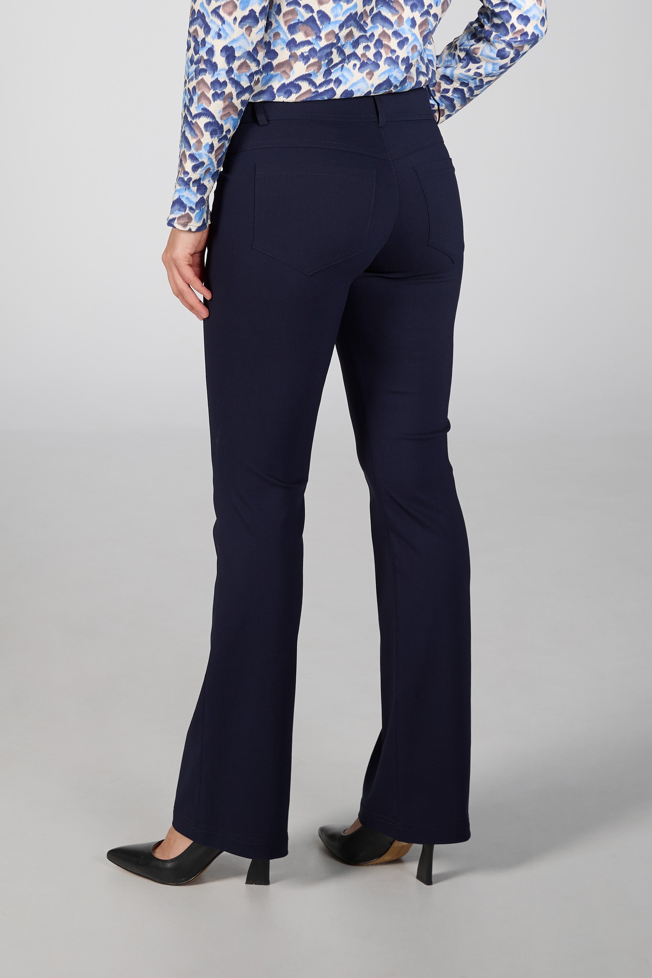 Navy blue pants worn by a person on a gray background back side view