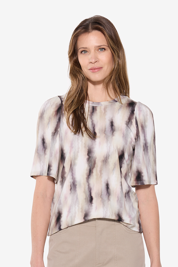 Woman wearing a patterned blouse on a white background