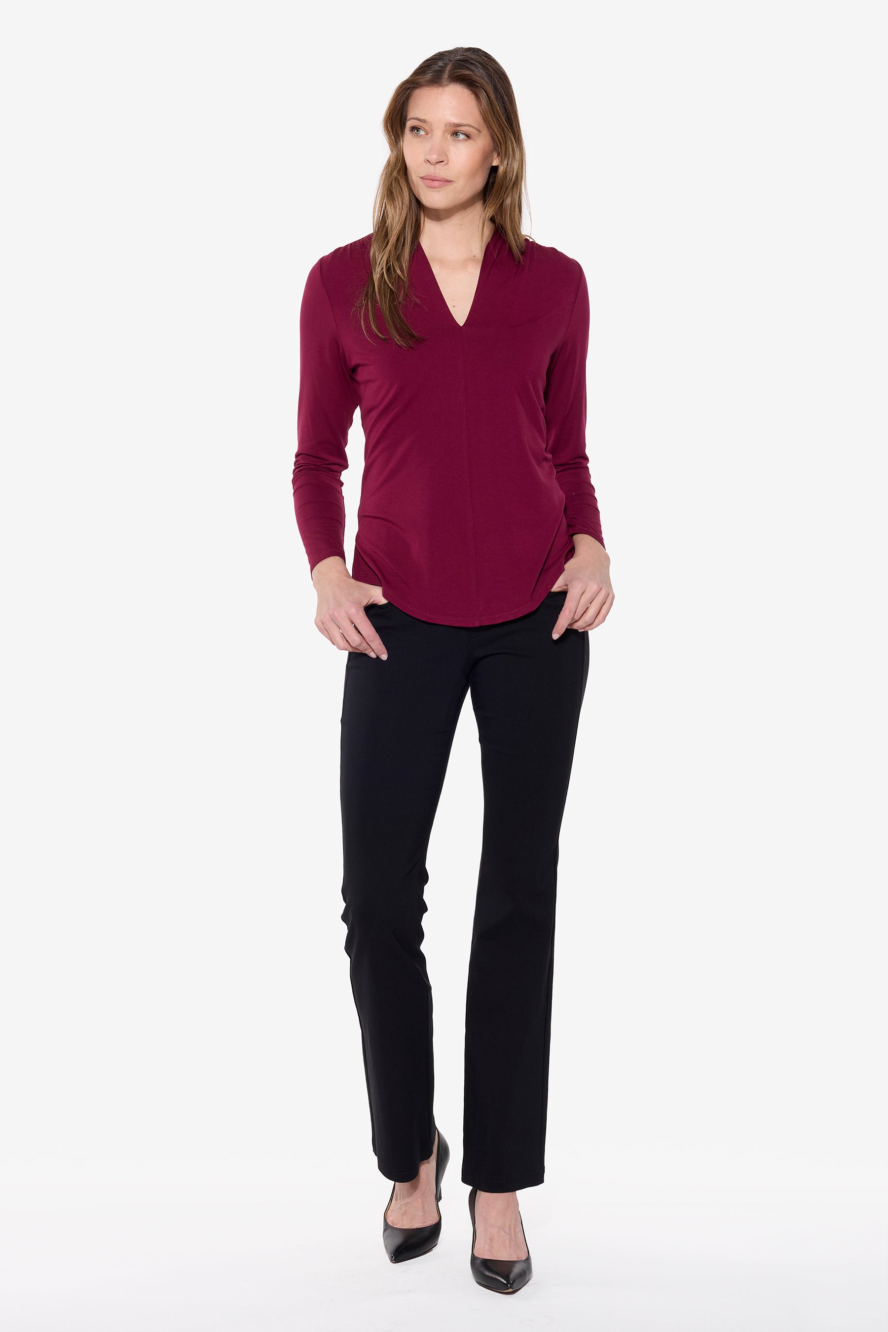 Woman wearing a burgundy top and black pants on a white background