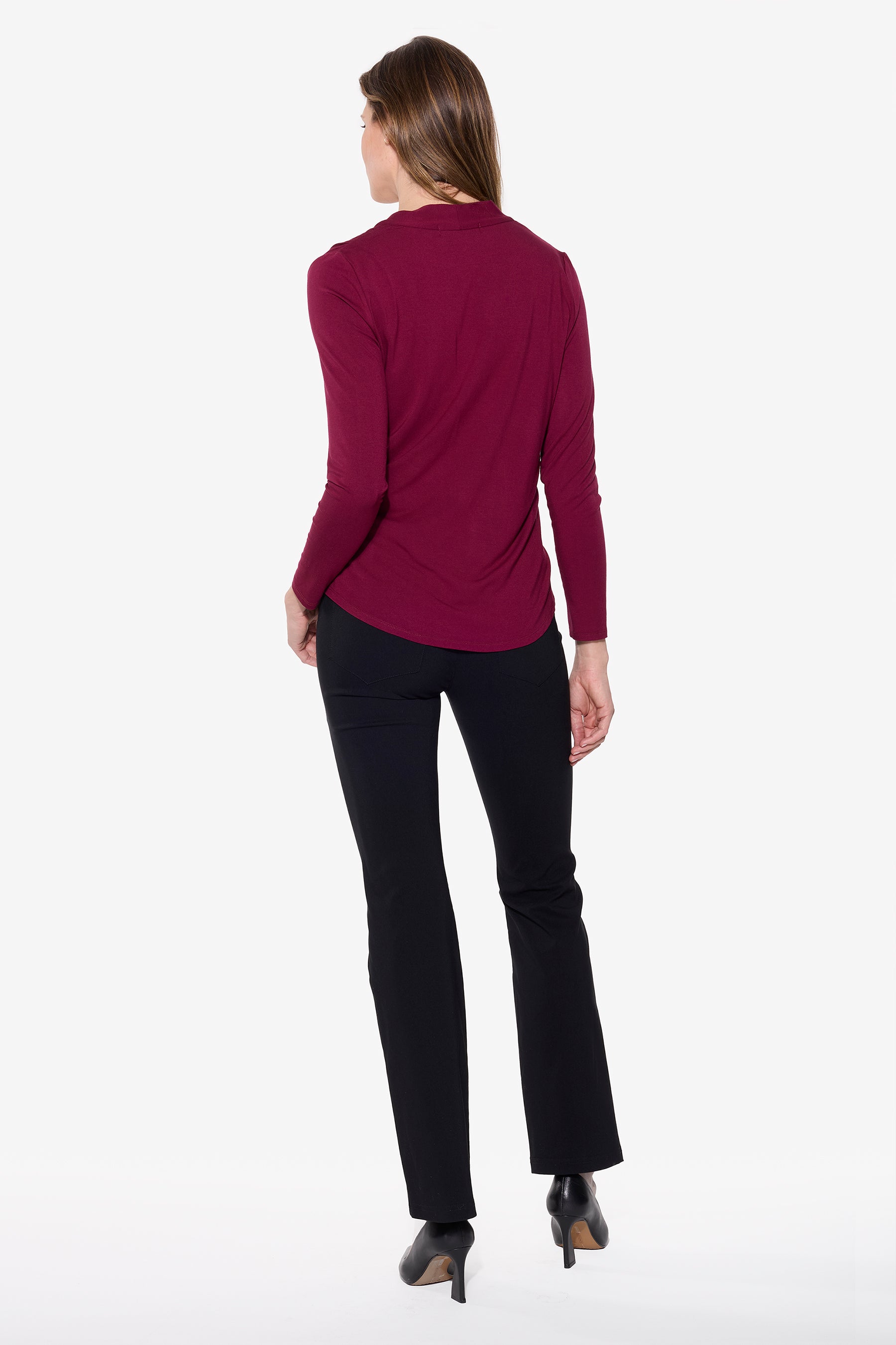 Person wearing a burgundy top and black pants on a white background