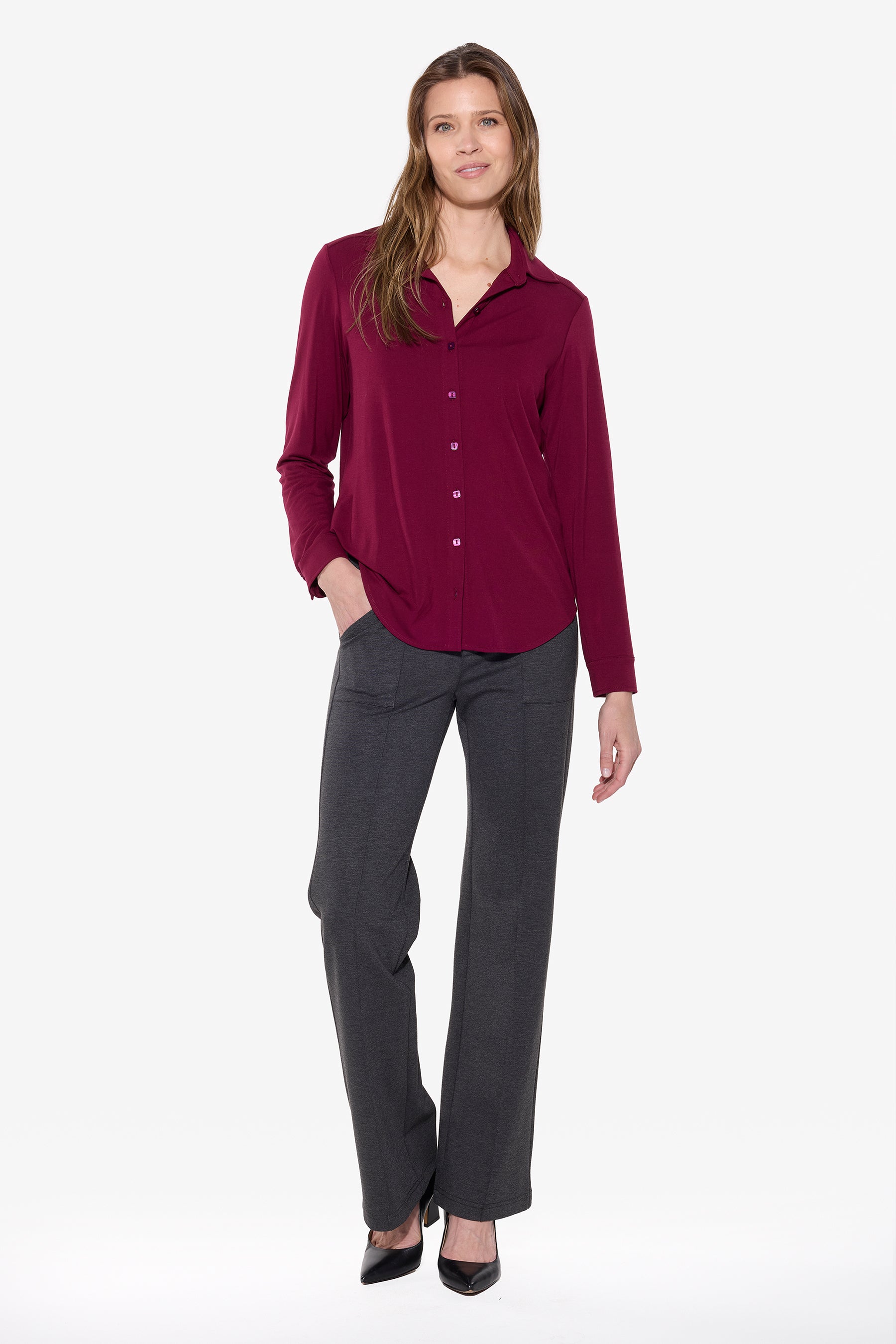 Woman wearing a burgundy shirt and gray pants on a white background