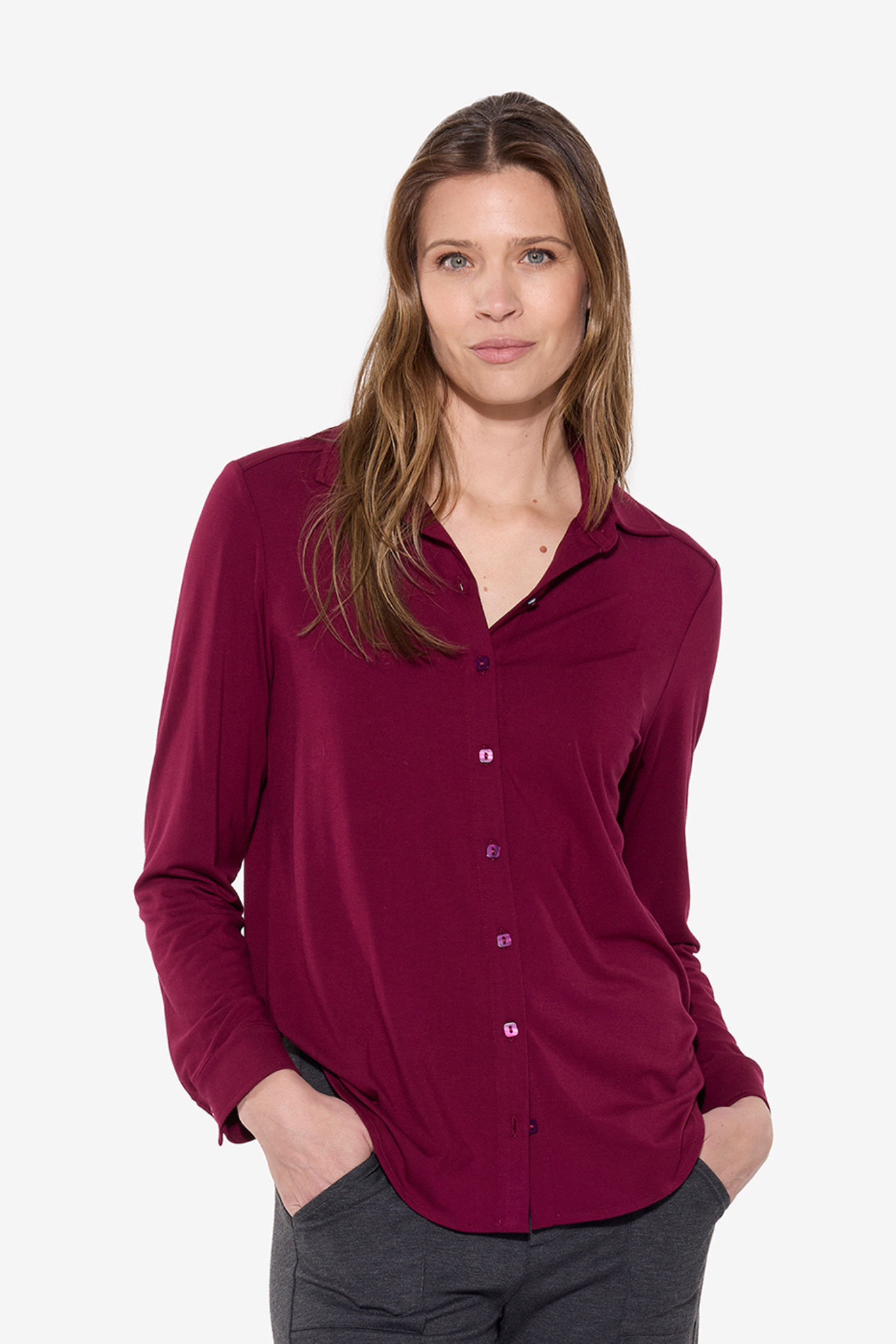 Woman wearing a burgundy shirt on a white background