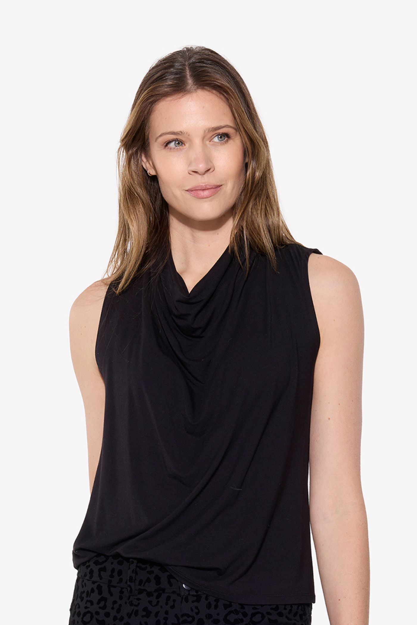 Woman wearing a black sleeveless top with a draped neckline on a white background
