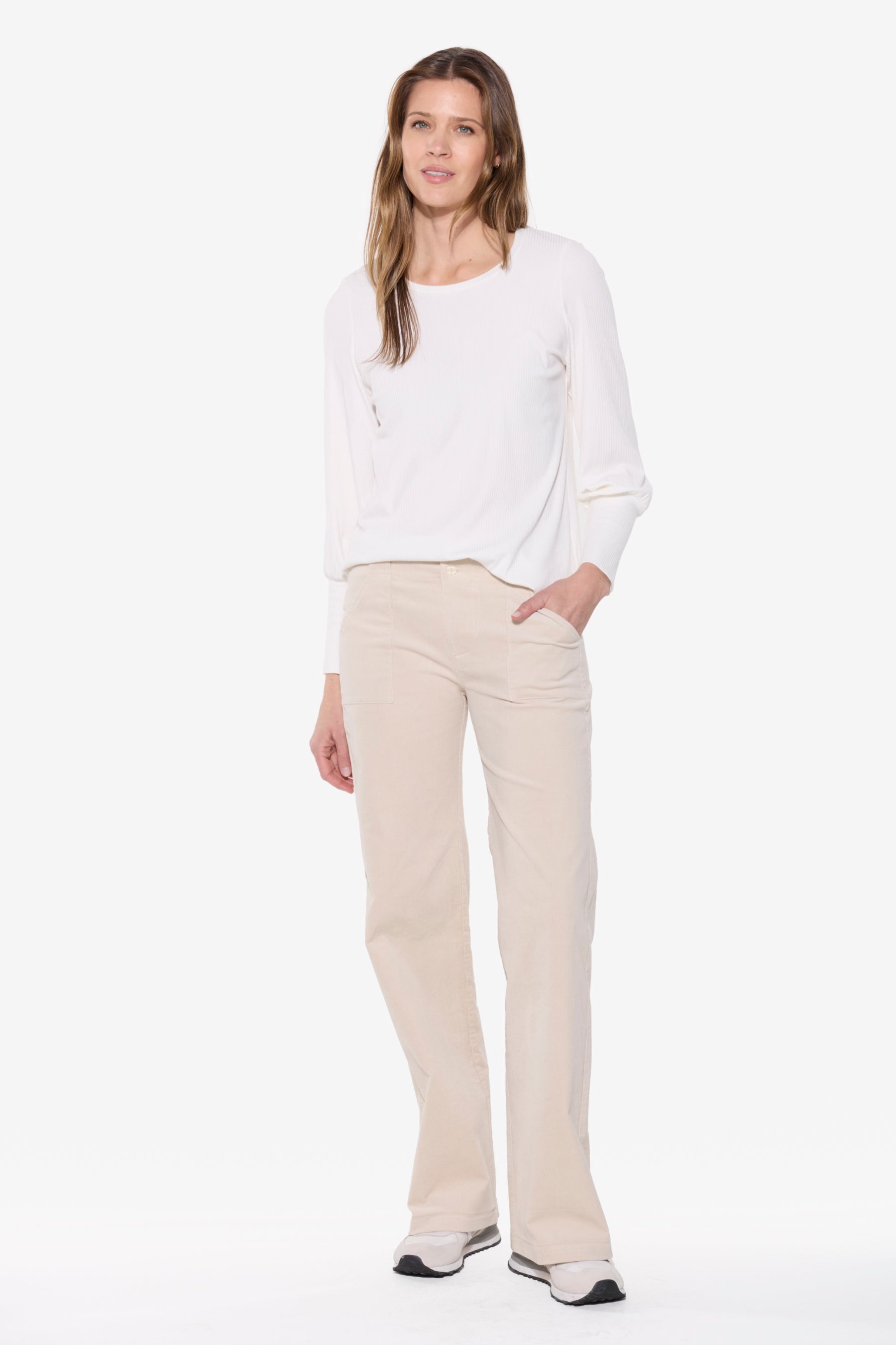 Woman wearing a white top and beige pants on a white background