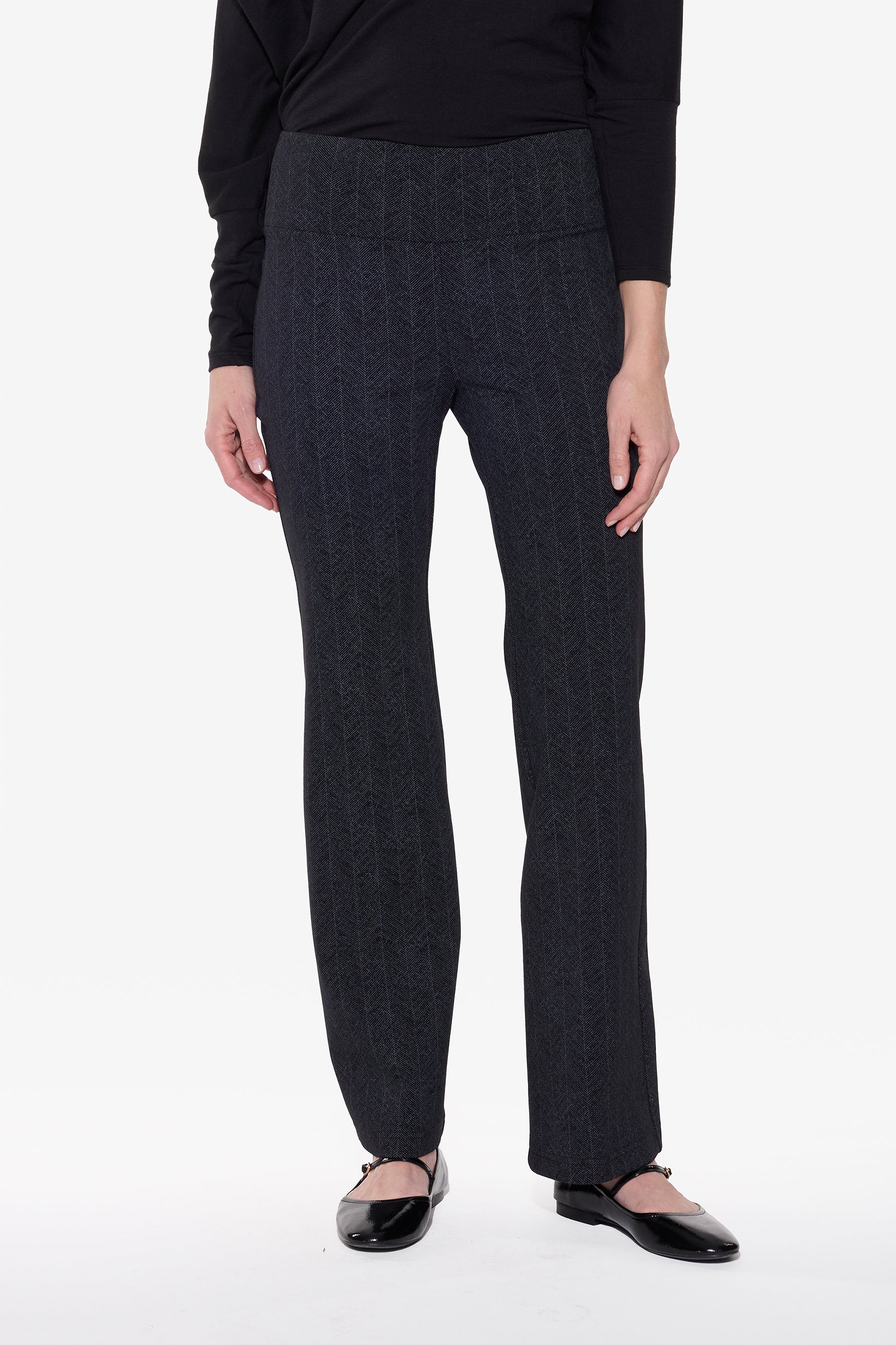 Person wearing dark gray checkered pants on a white background