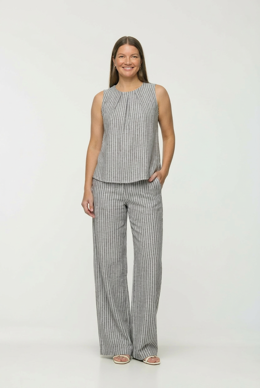 Woman wearing a striped sleeveless top and wide-leg pants on a white background