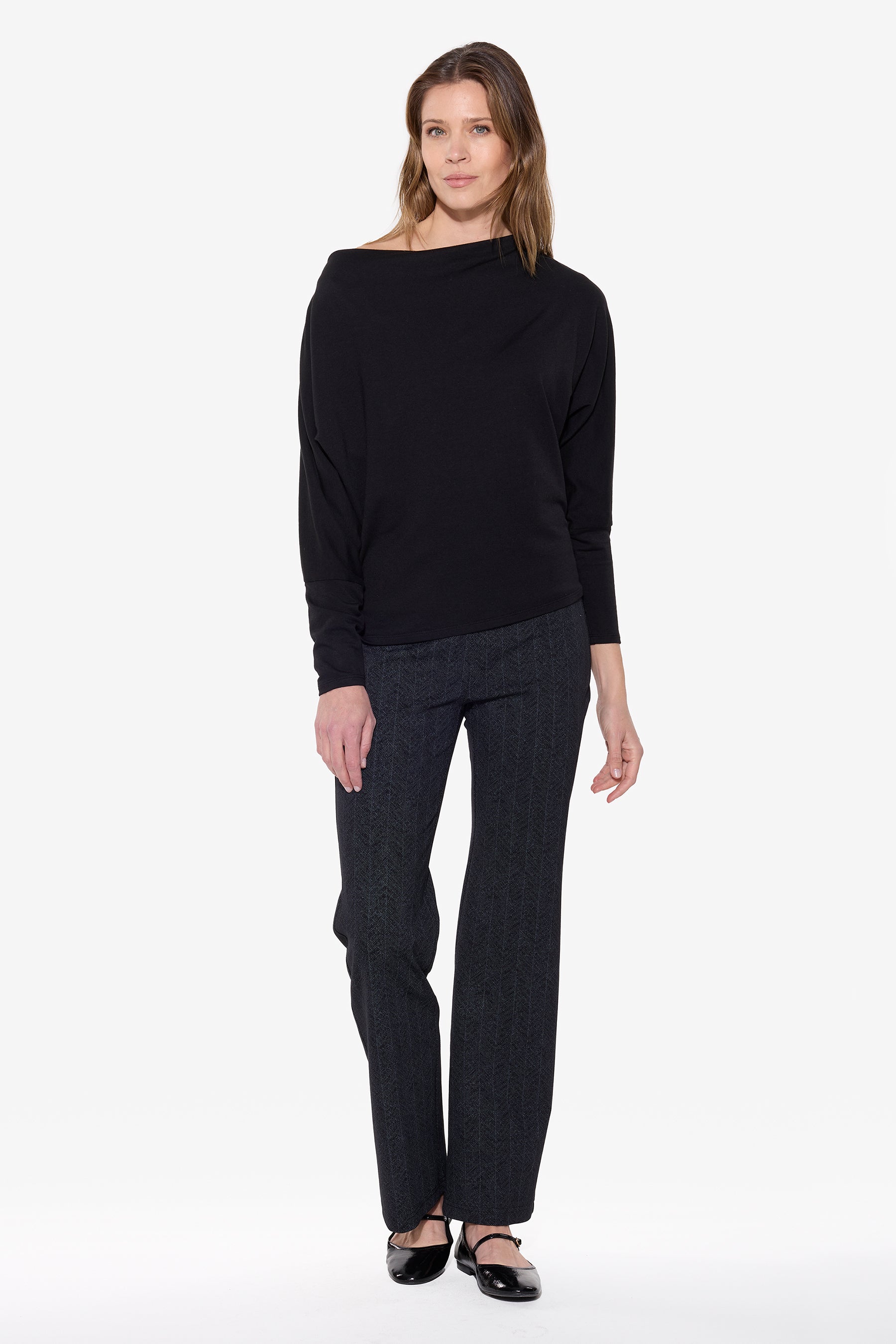 Woman wearing a black sweater and black chevron wearable wide leg pants on a white background
