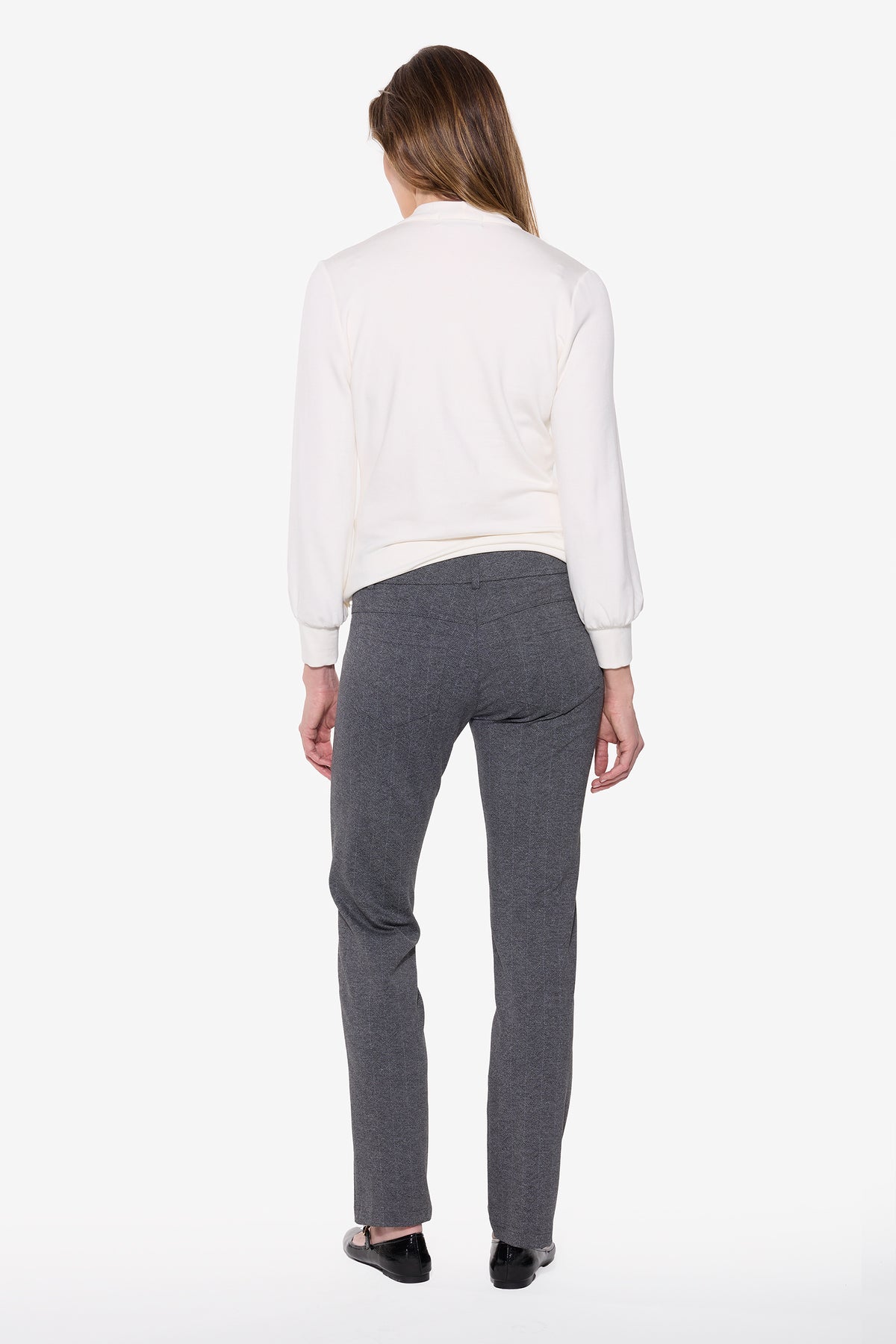 Person wearing a white shirt and grey chevron pants on a white background