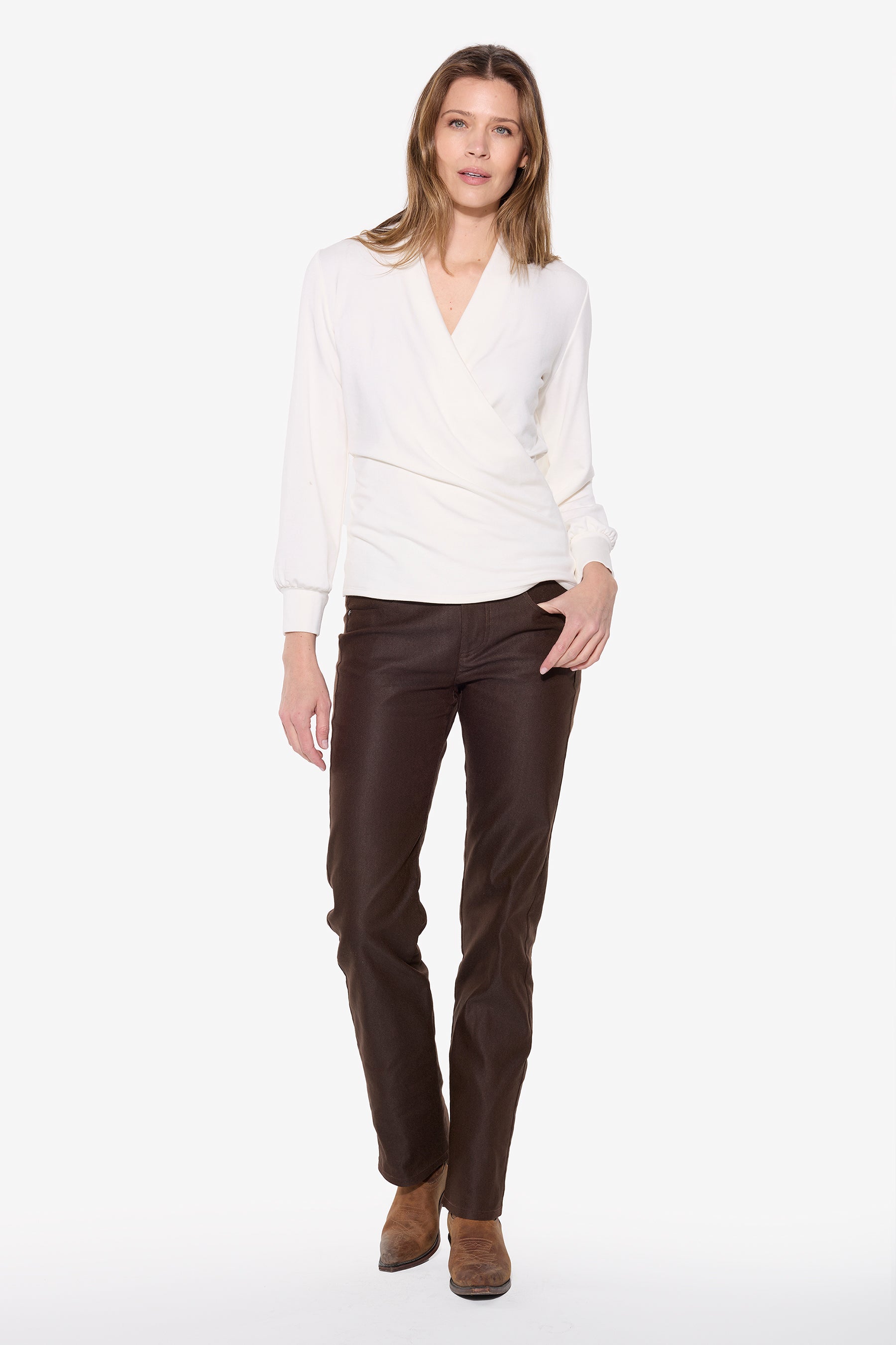 Woman wearing a white wrap top and brown jean on a white background