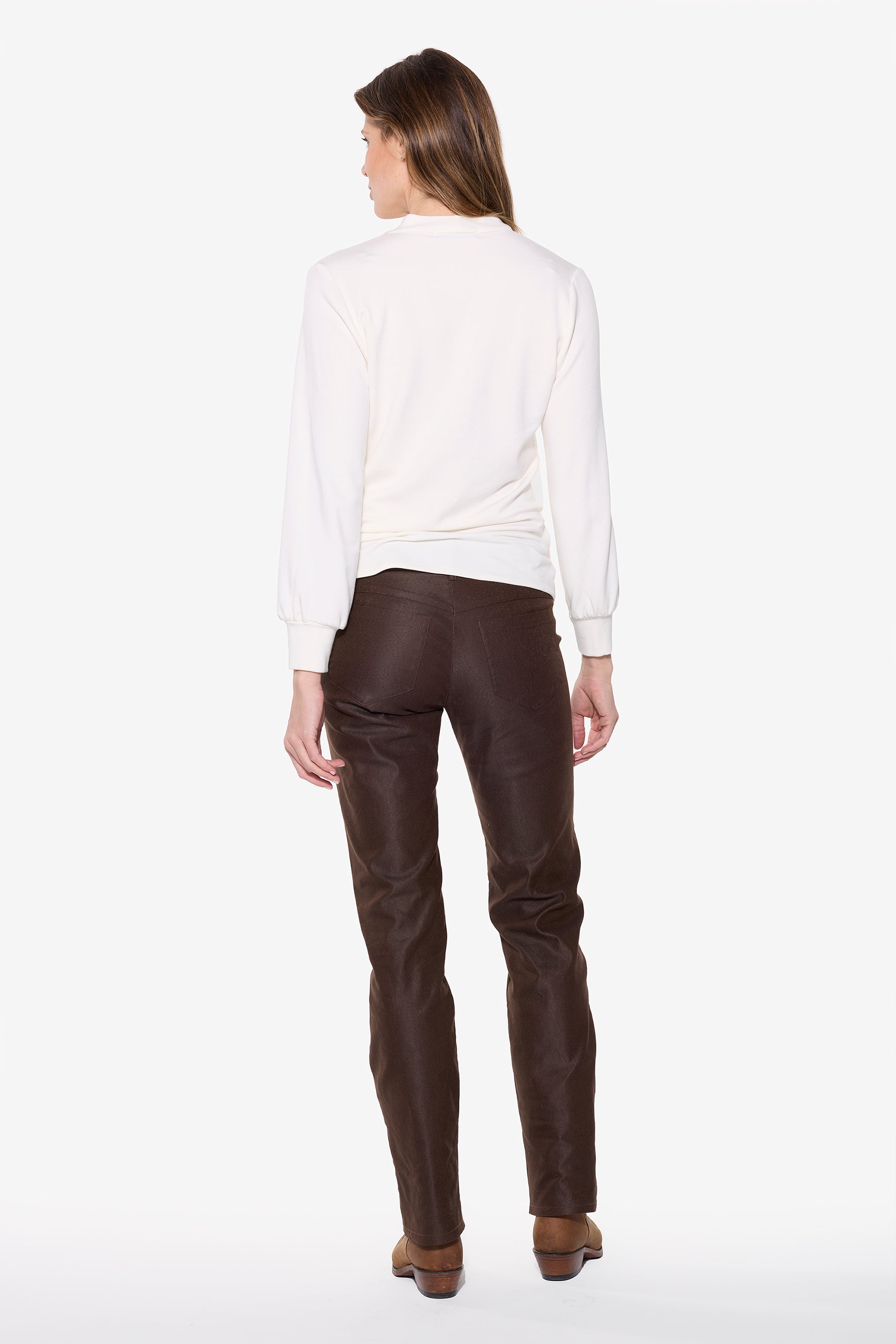 Woman wearing a white shirt and brown jeans on a white background