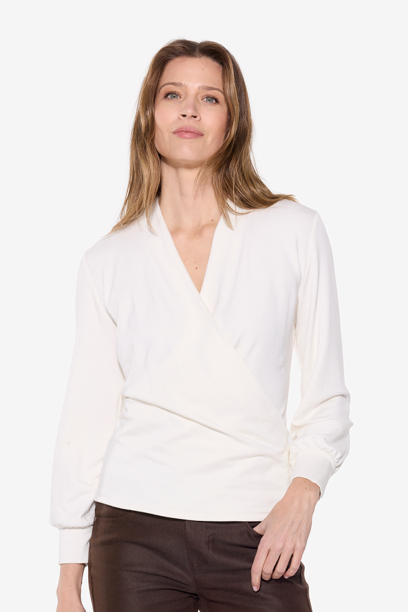 Woman wearing a white blouse with a V-neckline on a white background