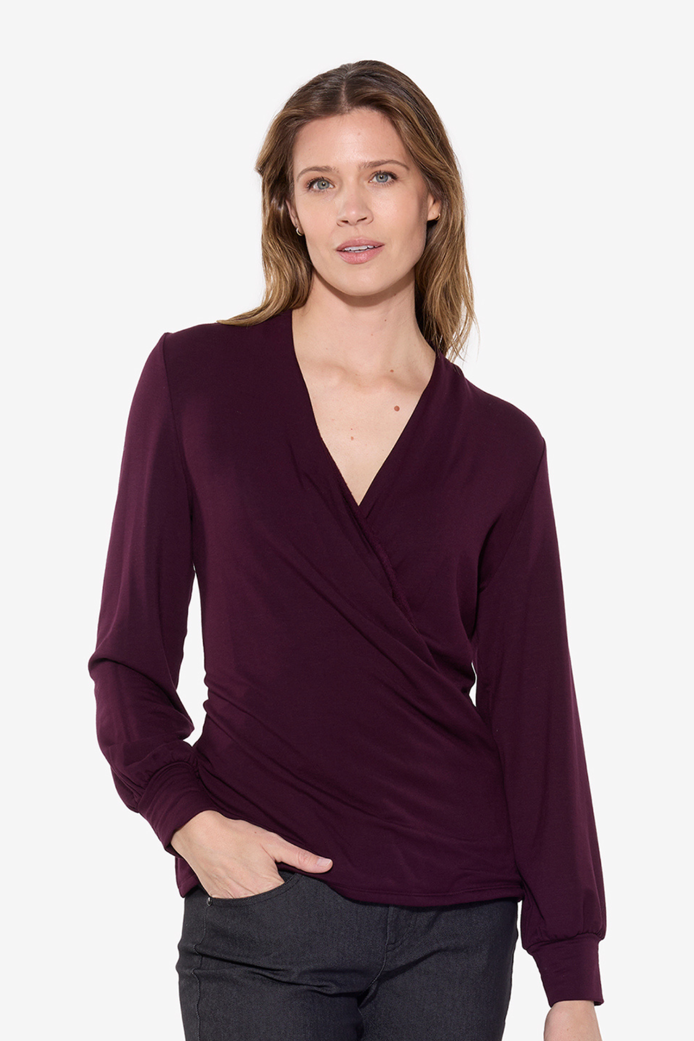 Woman wearing a merlot wrap-style top on a white background