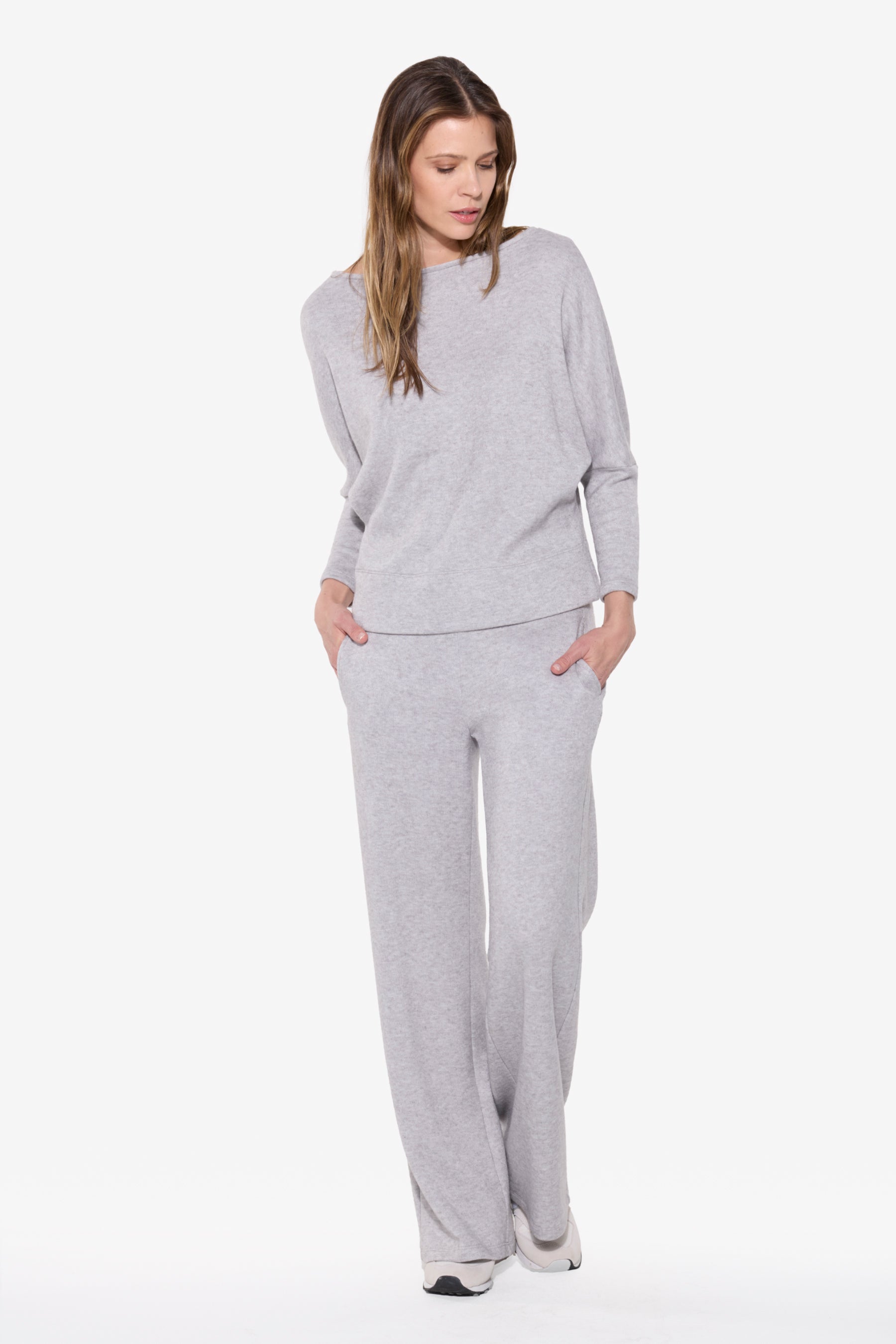 Woman wearing a gray lounge set on a white background