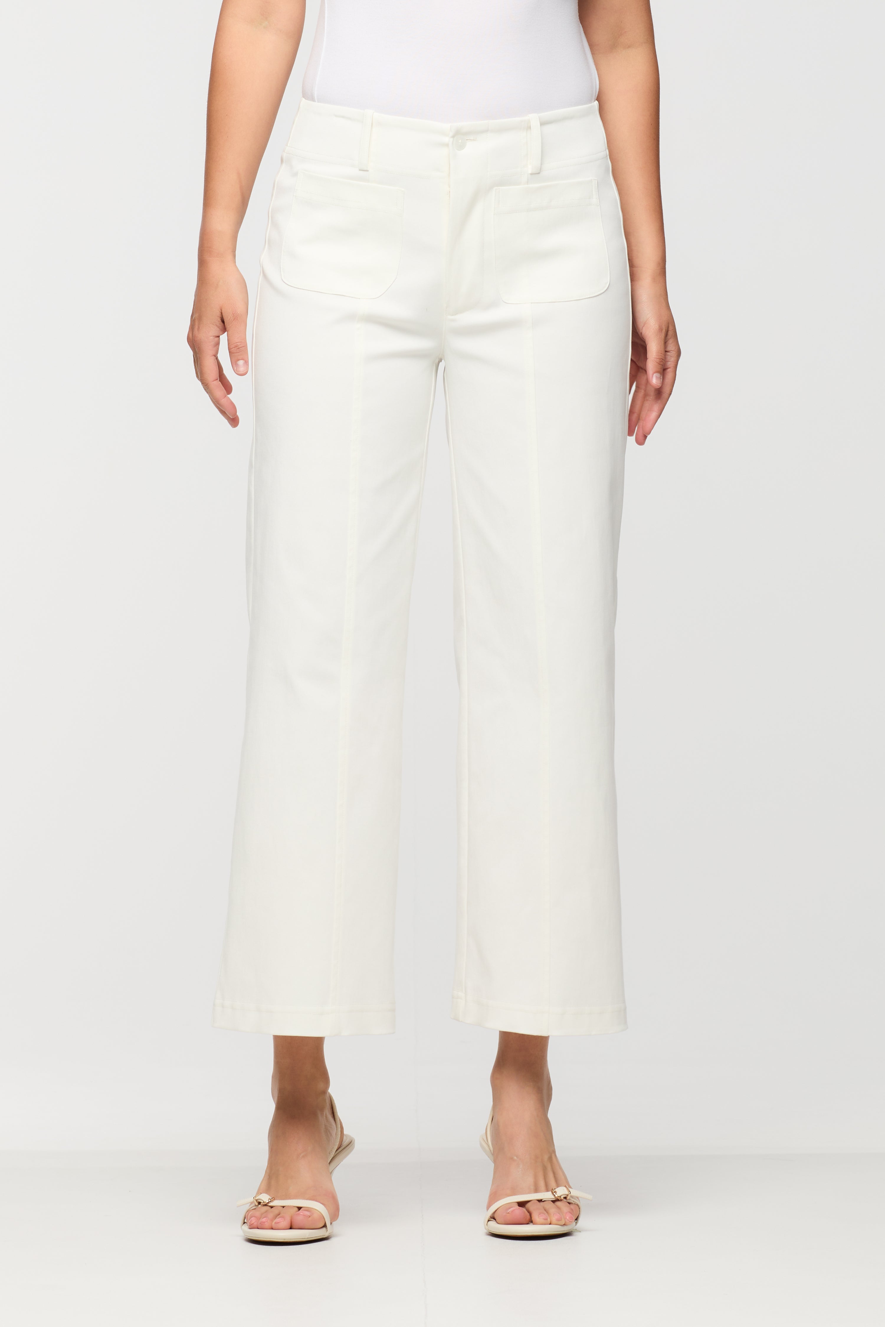 Person wearing white wide-leg pants on a plain background