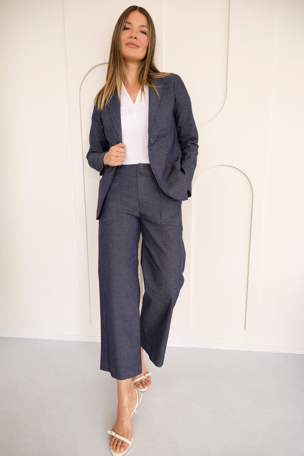Woman wearing a gray suit with a white shirt against a white background